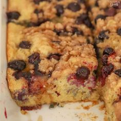 a close up of a cake with blueberries on it and crumbs around the edges