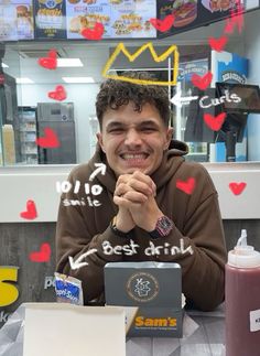 a man sitting at a table in front of a laptop computer with hearts on it