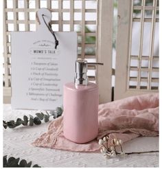 a pink soap dispenser sitting on top of a bed