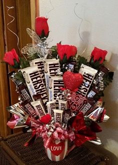 a valentine's day candy bouquet with roses and chocolate bars in the center, sitting on a wicker table