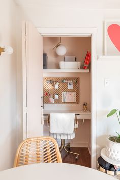 a white desk and chair in a room with a heart painted on the wall above it