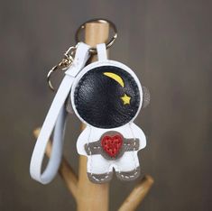 a keychain with an image of a spaceman holding a heart on it