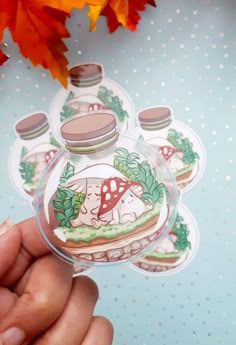 a hand holding a clear sticker with an image of a mushroom and mushrooms on it