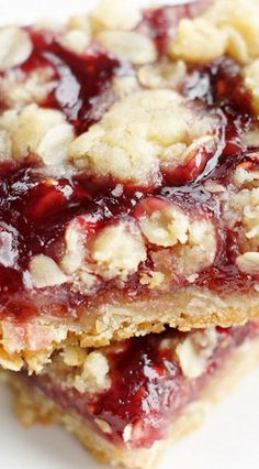 two pieces of dessert sitting on top of a white plate covered in jelly and oatmeal