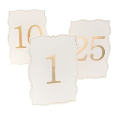 two white and gold table numbers with the number one on each side, set against a white background