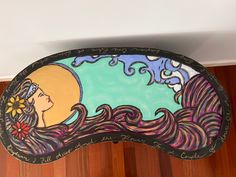 a decorative mirror with a woman's face painted on it