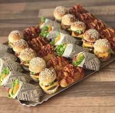 a tray filled with mini sandwiches covered in bacon