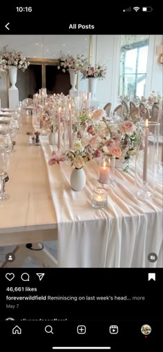 the table is set with candles, flowers and vases for an elegant wedding reception