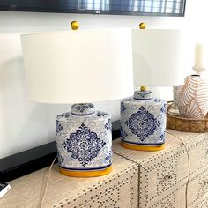 two blue and white vases sitting on top of a dresser