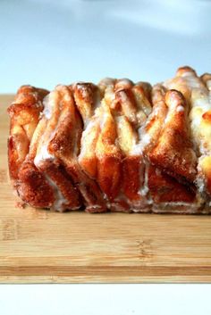 a loaf of cinnamon bundt bread sitting on top of a wooden cutting board with icing