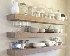 two wooden shelves filled with dishes and glasses