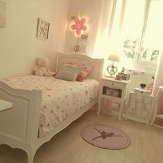 a bedroom with a bed, desk and teddy bear in the corner on the floor