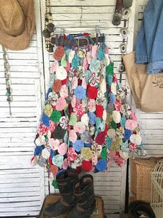 a bunch of clothes hanging up on a wall with hats and other items in the background