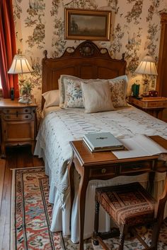 a bed sitting in a bedroom next to a table with a laptop on top of it