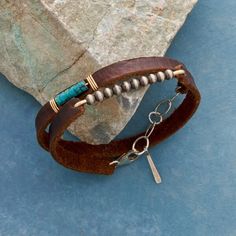 A wraparound length of supple brown leather displays two distinct segments: turquoise heishi beads wrapped atop the leather lacing, oxidized sterling silver beads bridging a gap. Exclusive. Handmade in USA with 14kt gold-filled wire; sterling silver lobster clasp. 13" to 14"L. Sundance Jewelry Catalog, Leather Jewelry Making, Unique Bangle, Womens Cuff Bracelets, Sundance Catalog, Beaded Wraps, Moon Jewelry, Fall Jewelry, Artistic Jewelry