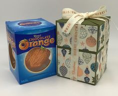 a box of chocolate next to a package of oranges