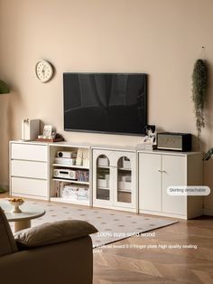 a flat screen tv sitting on top of a white entertainment center in a living room