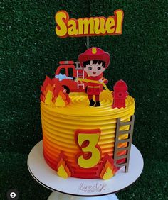 a birthday cake with a fireman on top and the number 3 in front of it