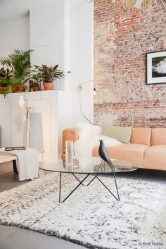 a living room filled with furniture and a brick wall in the back drop off area