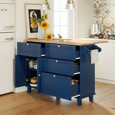 a kitchen with blue cabinets and wooden counter tops in front of a white refrigerator freezer