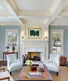 a living room filled with furniture and a fire place in the middle of a room