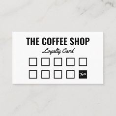 the coffee shop business card is displayed on a white marble surface with black and white squares