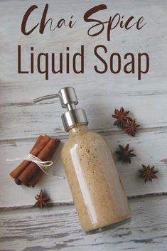 a soap dispenser with cinnamon and star anise around it on a white wooden background