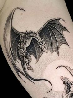 a black and white dragon tattoo on the arm