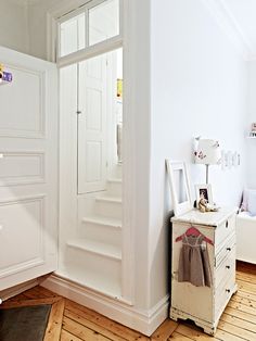 a bedroom with white walls and wooden floors