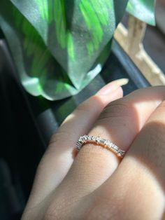 a close up of a person's hand with a wedding ring on their finger