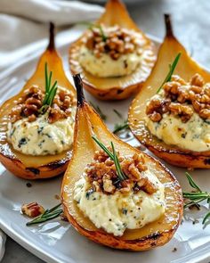 four pears with cream cheese and walnuts on a white plate, ready to be eaten