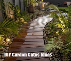 a wooden walkway is surrounded by plants and rocks, along with lights on either side