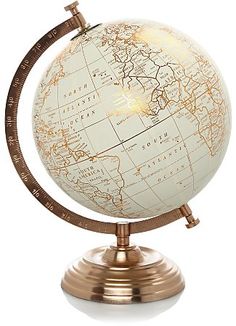 an illuminated globe on a metal stand with a white and gold color map in the center