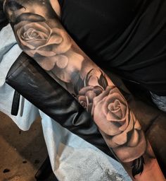 a person with a tattoo on their arm that has three roses and one is black and white