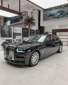 a black rolls royce parked in a showroom