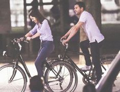 the man and woman are riding their bikes together