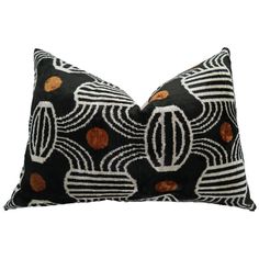 a black and white pillow with orange circles on it