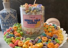 a bowl filled with cereal mix next to two vases on a table and one has a stick sticking out of it