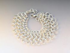 Beautiful sterling silver chainmaille weave bracelet, handwoven one ring at a time and tumble polished for a high shine and smooth finish. This is a heavy bracelet, that is sure to be noticed, fastens with a secure lobster clasp, and is a full 1" in width. Standard length is 7", please leave me a note at checkout if you require a different size. To determine your proper size for a  chain style bracelet, measure your wrist with a seamstress tape. A half inch more than your measurement will fit we Chainmail Bracelet For Jewelry Making, Silver Chainmail Bracelet With Chain Link, Silver Chainmail Chain Link Bracelets, Silver Chain Bracelet With Jump Ring, Weave Bracelet, Chainmaille Bracelet, Graffiti Alphabet, Tangle Patterns, Celtic Art