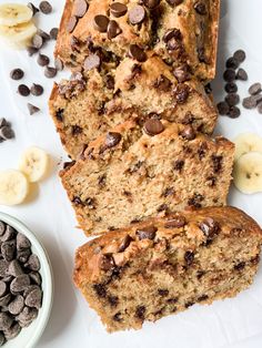 slices of banana chocolate chip bread on top of paper next to bananas and chocolate chips