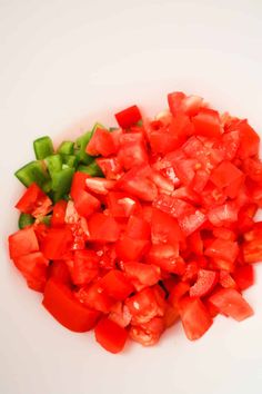 chopped tomatoes and green peppers on a white plate