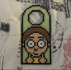 a cell phone case made to look like an old school video game character with a keychain hanging from it