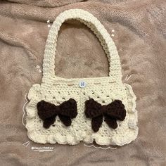 a crocheted purse with brown bows on it