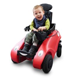 a young boy riding on the back of a red toy car