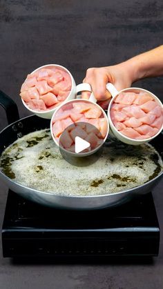 someone is cooking food in a pan on top of the stove with four other bowls