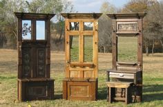 three wooden furniture sitting on top of a grass covered field