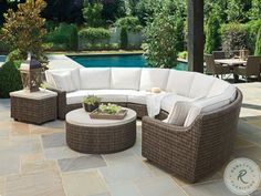 a couch and table on a patio next to a pool