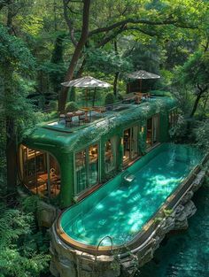 a green boat floating on top of a river surrounded by lush green trees and greenery