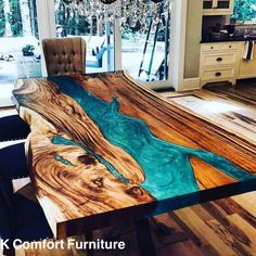 a dining room table made out of wood with blue paint on the top and bottom