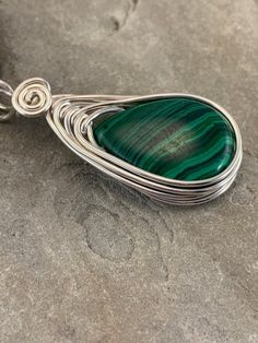 This Malachite necklace is simple yet elegant.  Malachite is a beautiful green color with unique striping/bands of color. I chose to enhance this beautiful smoothstone with a Celtic inspired silver wire design to let the natural beauty of the gemstone shine. This necklace is handmade by me with a synthetic malachite stone The necklace you will receive will be similar to the one in the picture, each stone is unique. The 4th photo in my listing shows the subtle variations of these Beautiful genuin Green Malachite Handmade Necklace, Handmade Green Malachite Necklaces, Handmade Green Malachite Necklace, Green Malachite Wire Wrapped Jewelry, Green Wire Wrapped Pendant Necklace, Green Teardrop Wire Wrapped Jewelry, Green Wire Wrapped Teardrop Jewelry, Green Adjustable Teardrop Necklaces, Adjustable Teardrop Green Necklace